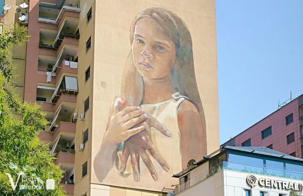 mural de una niña con su madre en tirana arte callejero