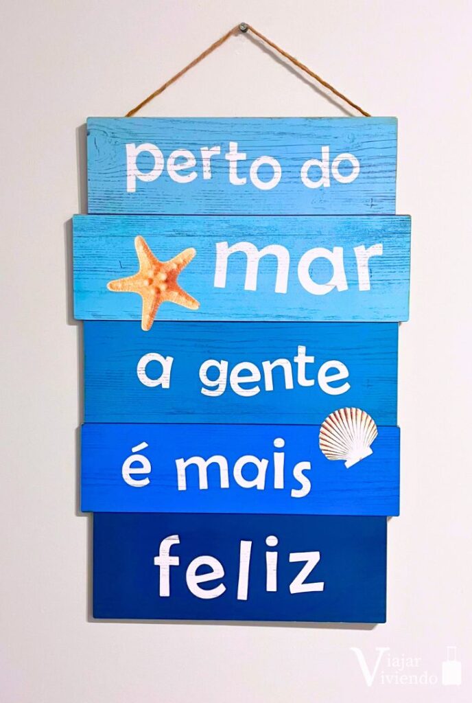 cartel en alojamiento de brasil que dice en portugues cerca del mar la gente es mas deliz