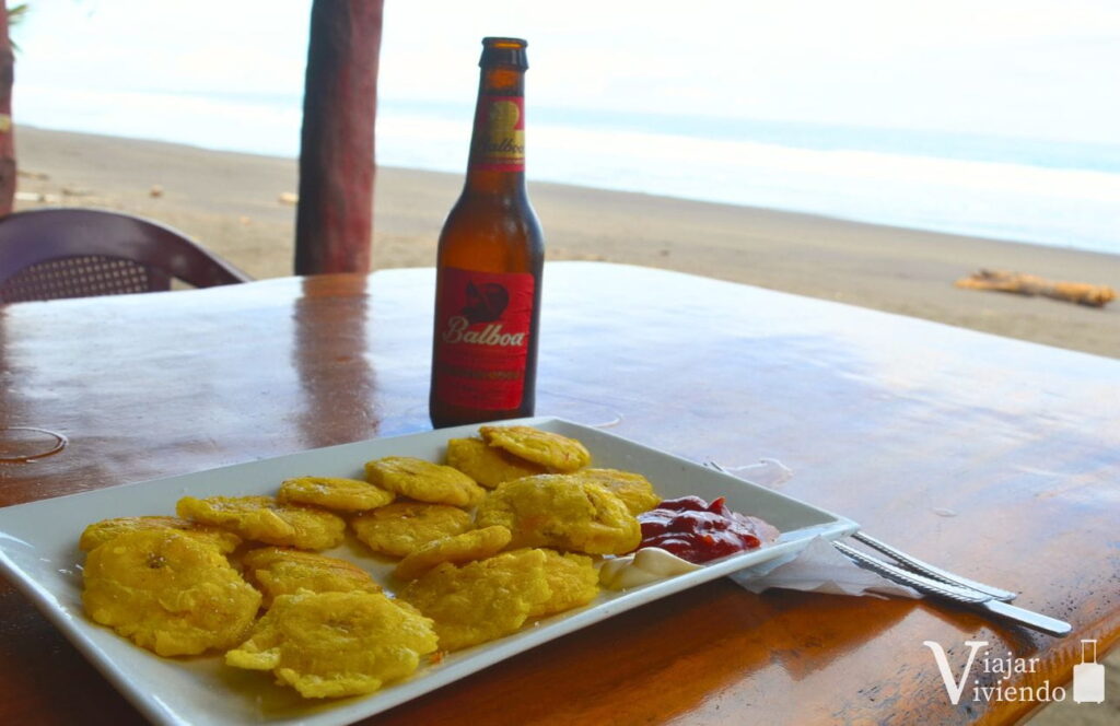 plato tipico de patacones con cerveza balboa de panama junto al mar
